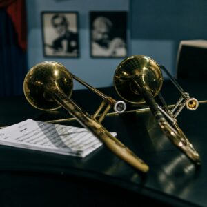 Close-up of two trombones and sheet music in a jazz setting.