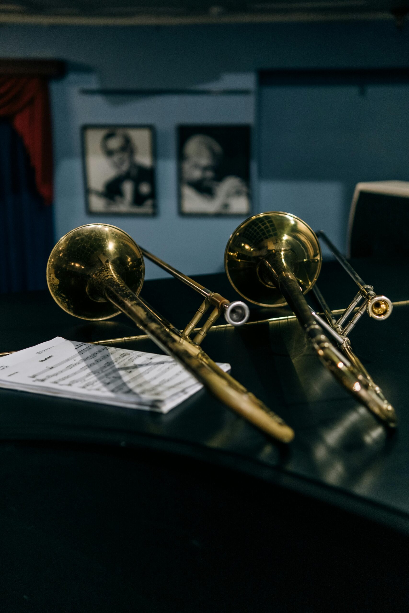 Close-up of two trombones and sheet music in a jazz setting.